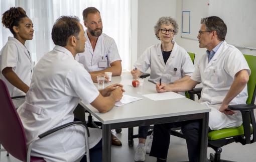 Artsen verzamelen rond een tafel voor een overleg