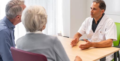 Medisch specialist in gesprek met patiënten in spreekkamer